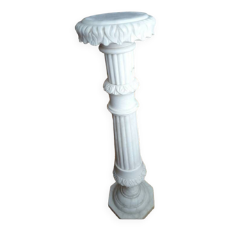 Colonne sellette en marbre blanc cannelé à motifs floraux.