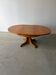 Round extendable dining table with cross legs.