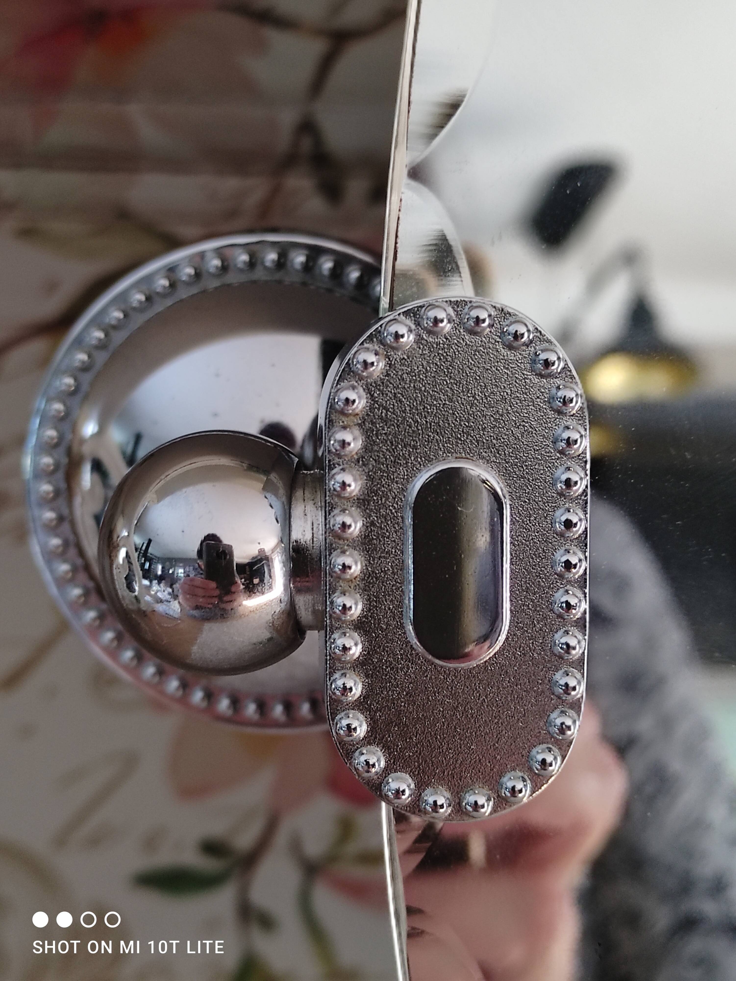 Miroir ovale biseauté vintage années 70 avec ses accroches murales en métal couleur argent