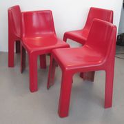 Four red fibreglass chairs from the 1970s.