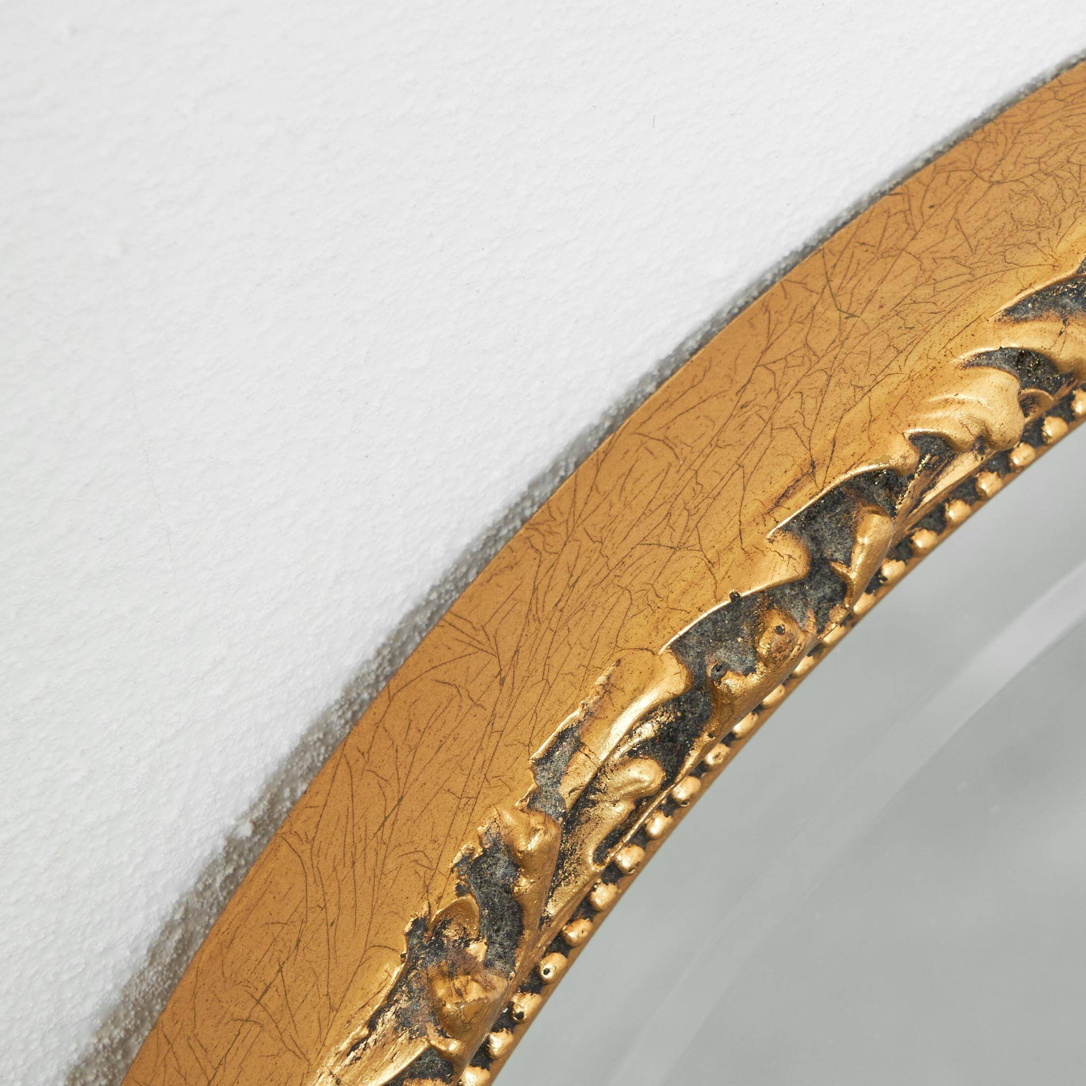 Oval mirror with gilded wood from the 1960s.