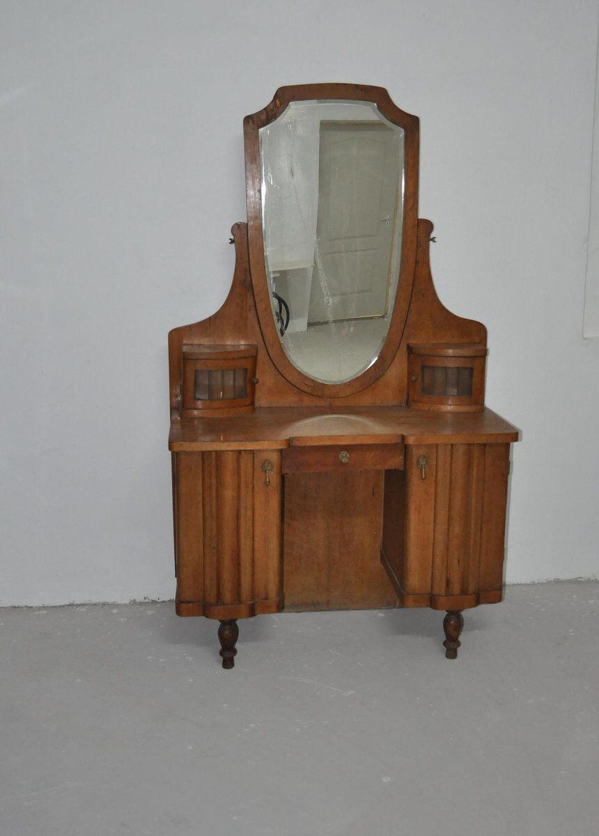 Large vintage brown wooden dressing table with an oval mirror and built-in storage.