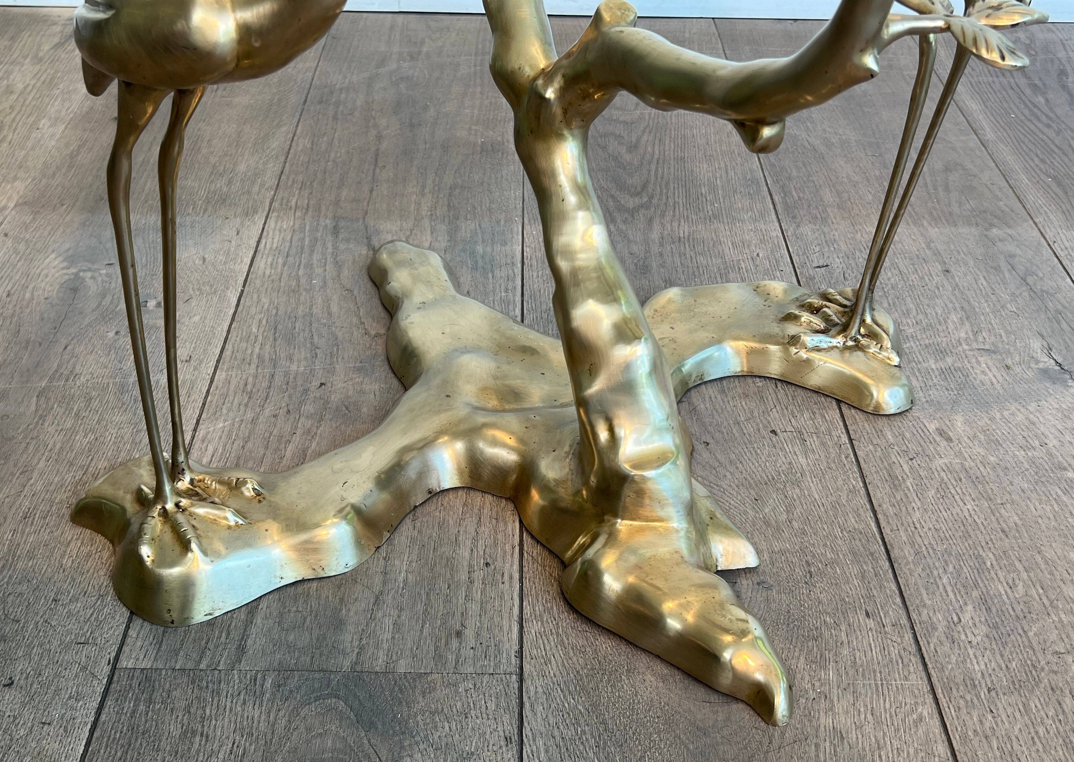 Coffee table model with cranes surrounding a brass bonsai and round glass top by Willy Daro.
