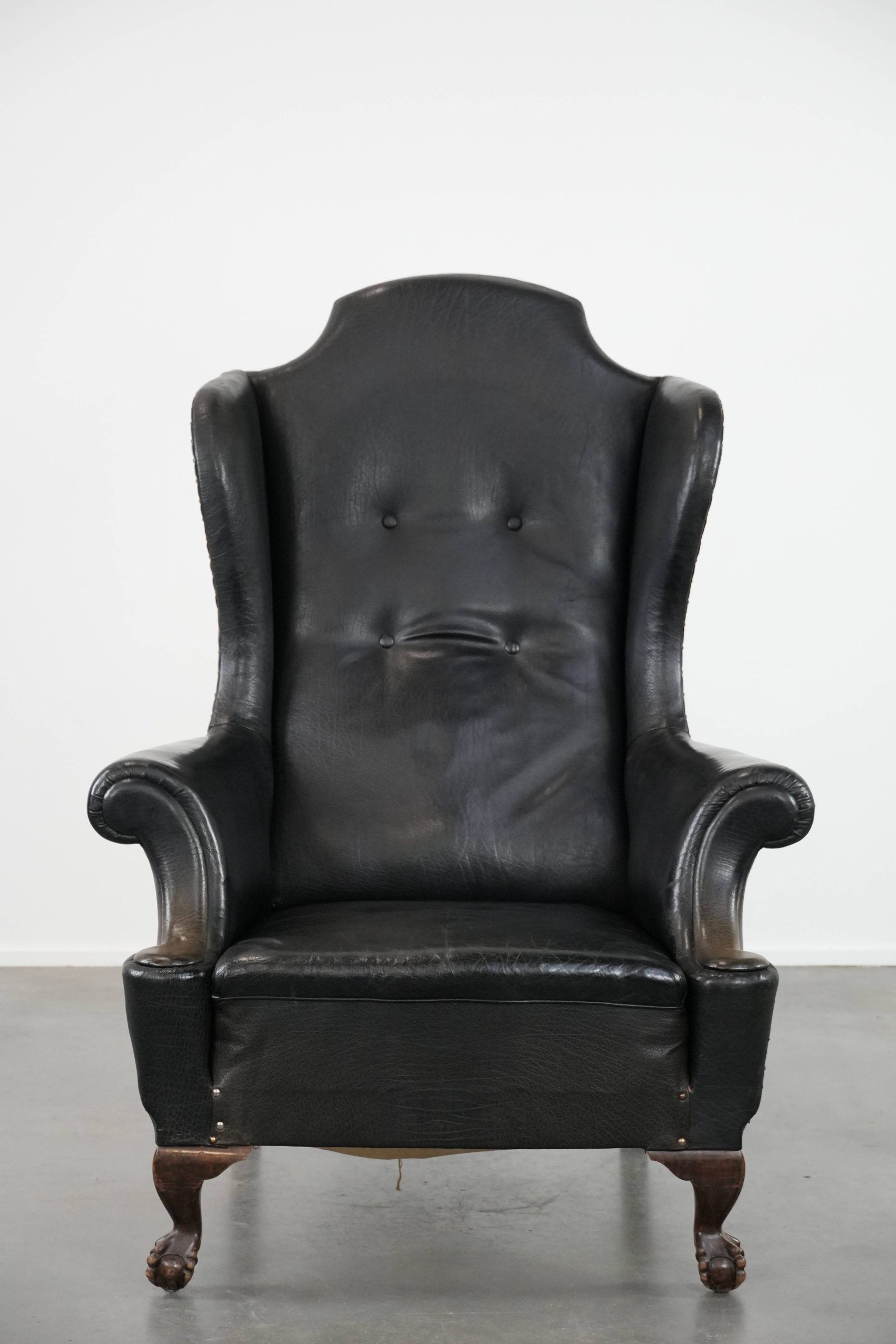 Antique black English cow leather wingback armchair from the 19th century