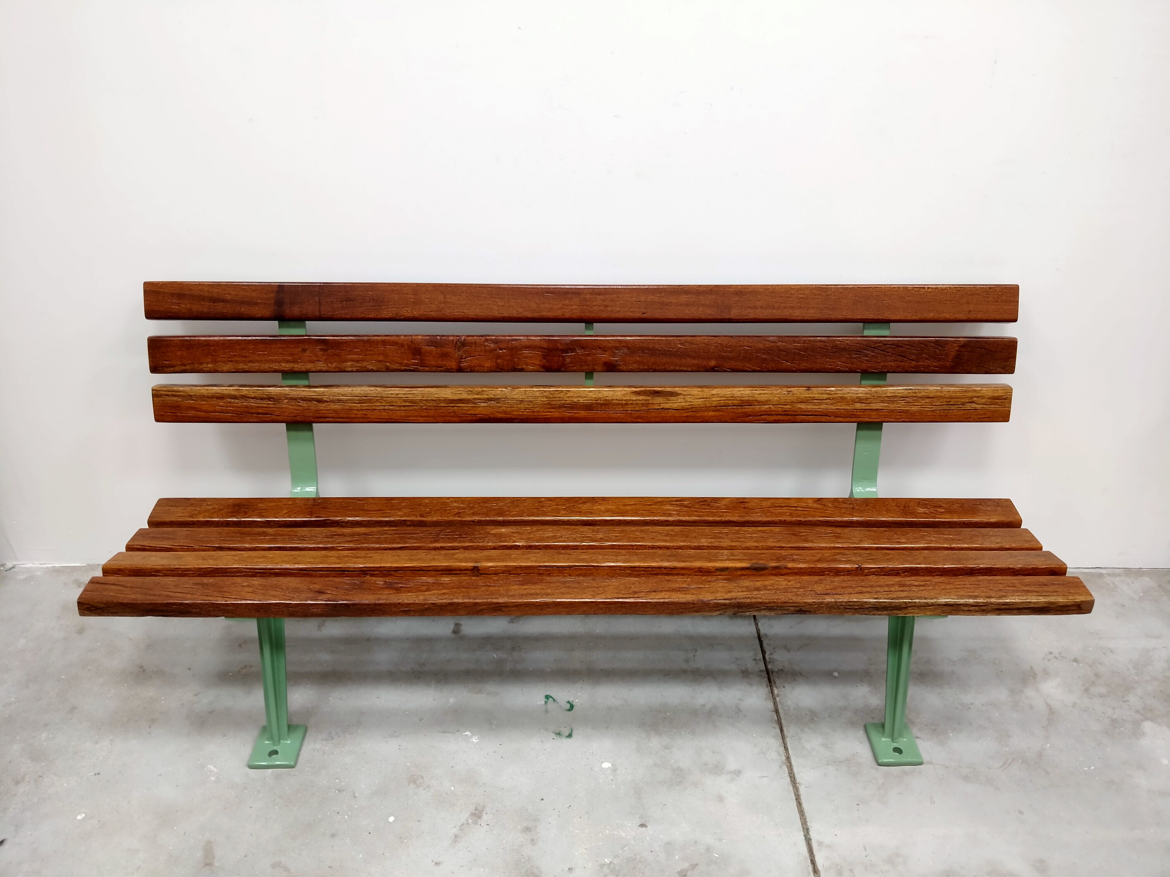 Restored and varnished garden bench in hardwood and olive green metal