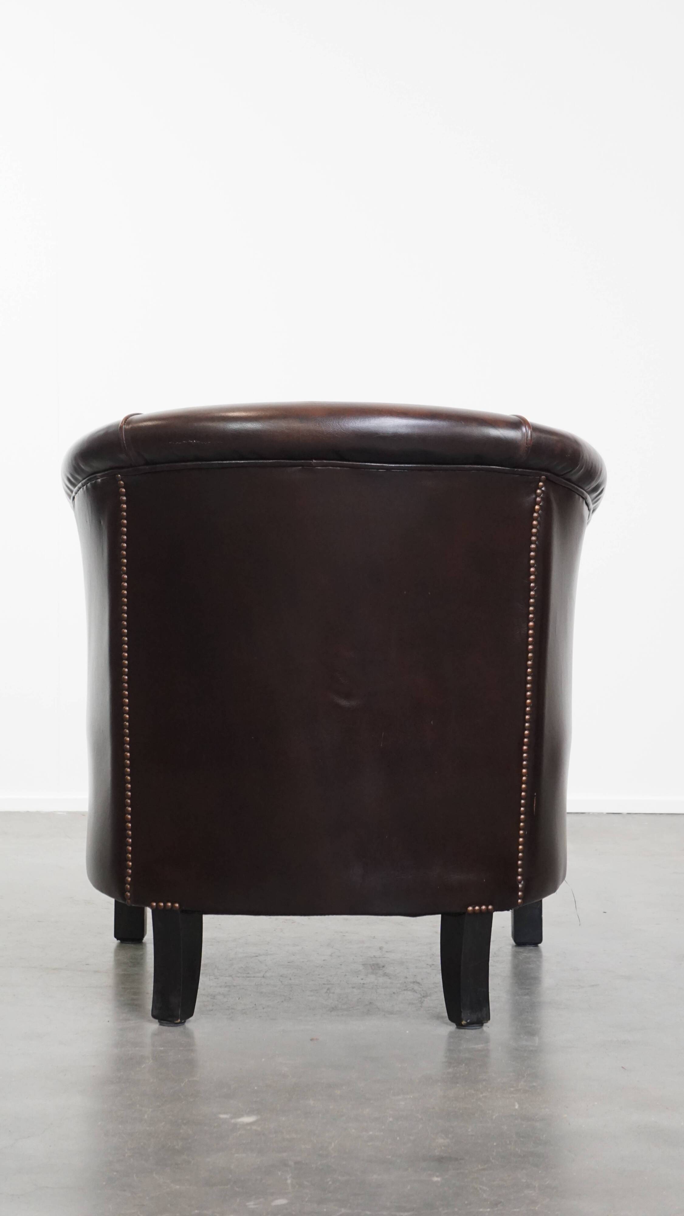 Fauteuil club de couleur foncée en cuir de vachette