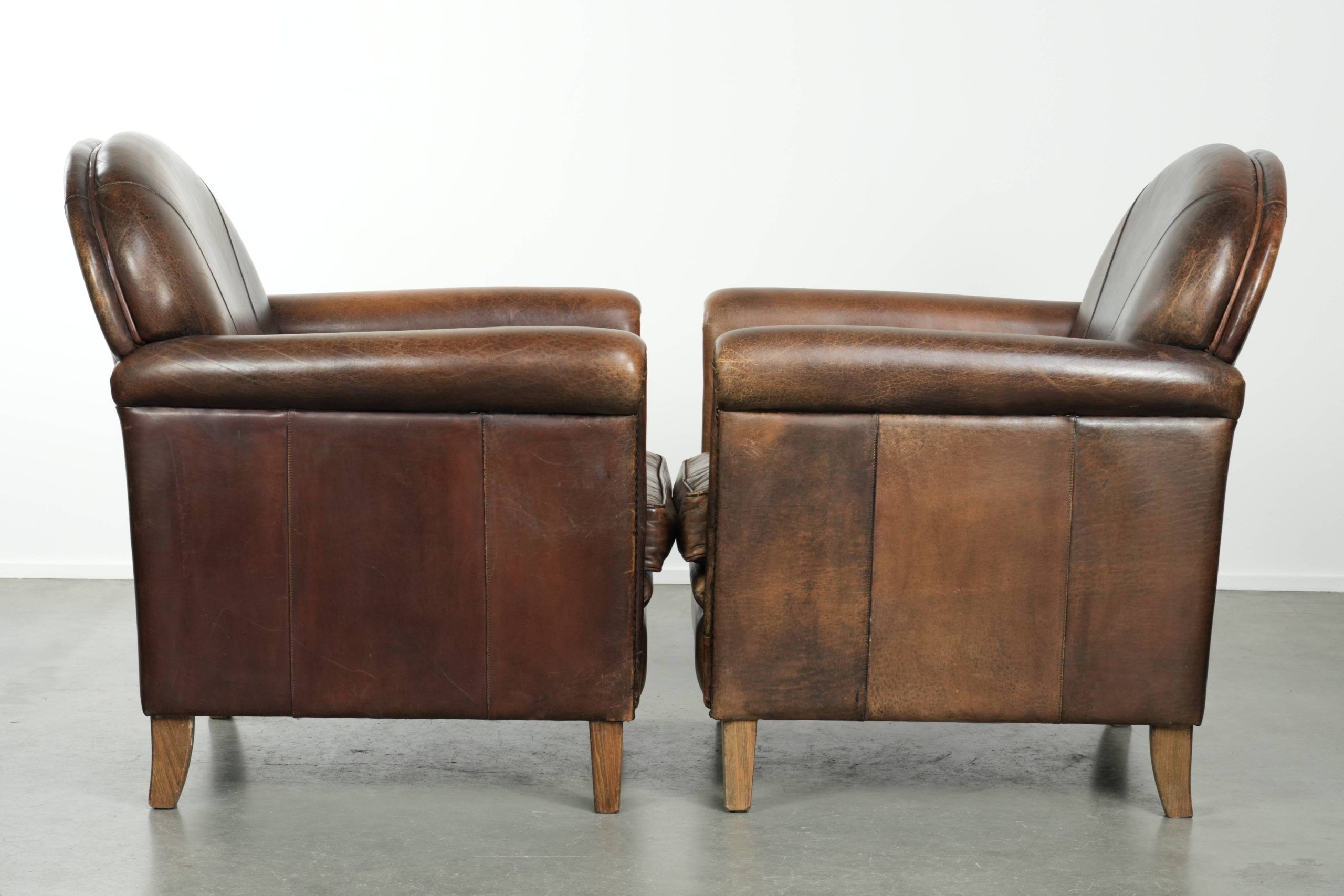 Characterful set of two sheepskin design armchairs with beautiful patina
