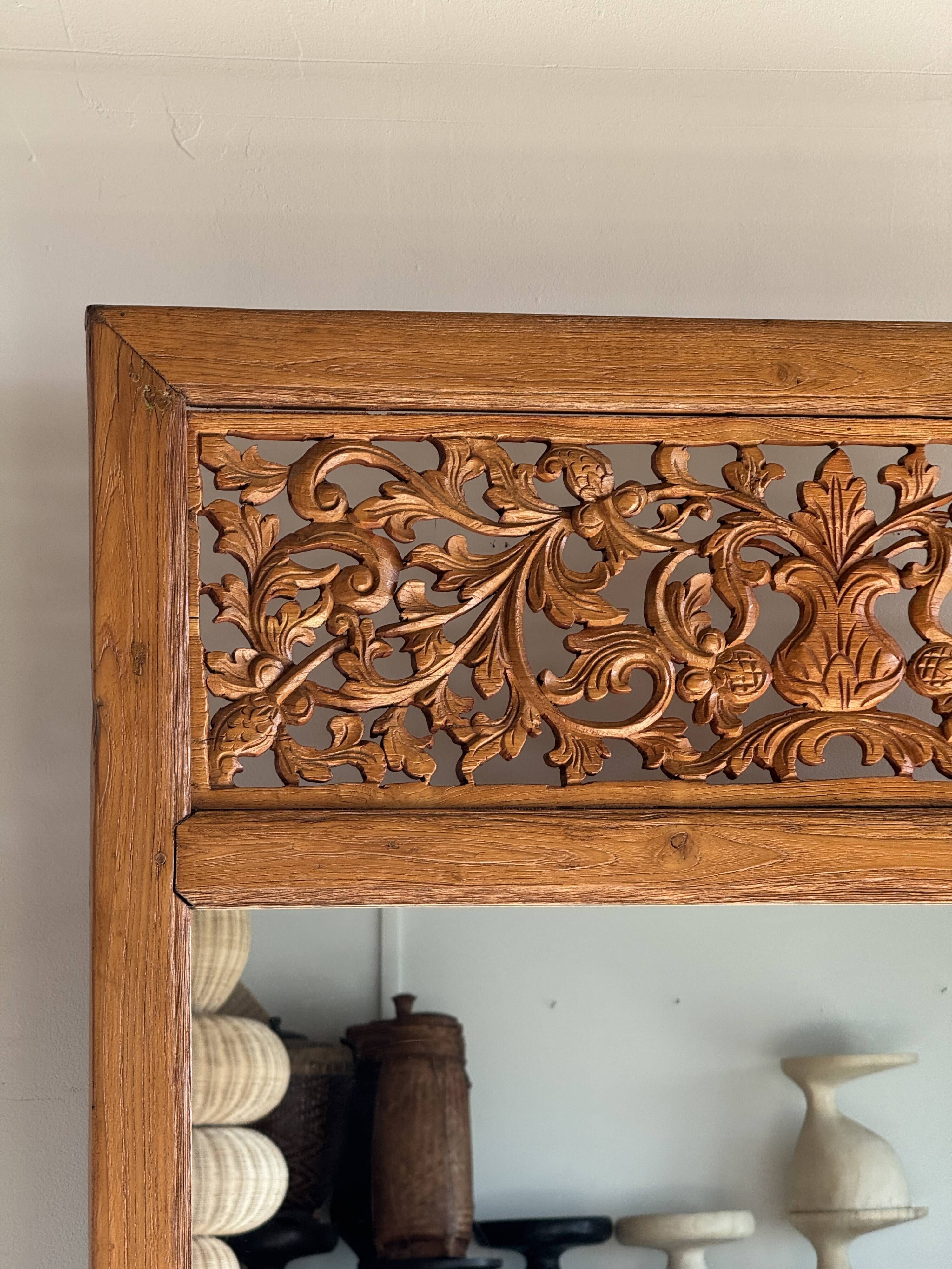 Very large freestanding teak mirror with an openwork carved pediment, Indonesia.