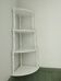 Corner shelf made of turned wood painted white.