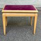 Adjustable piano stool in light beech and purple velvet.