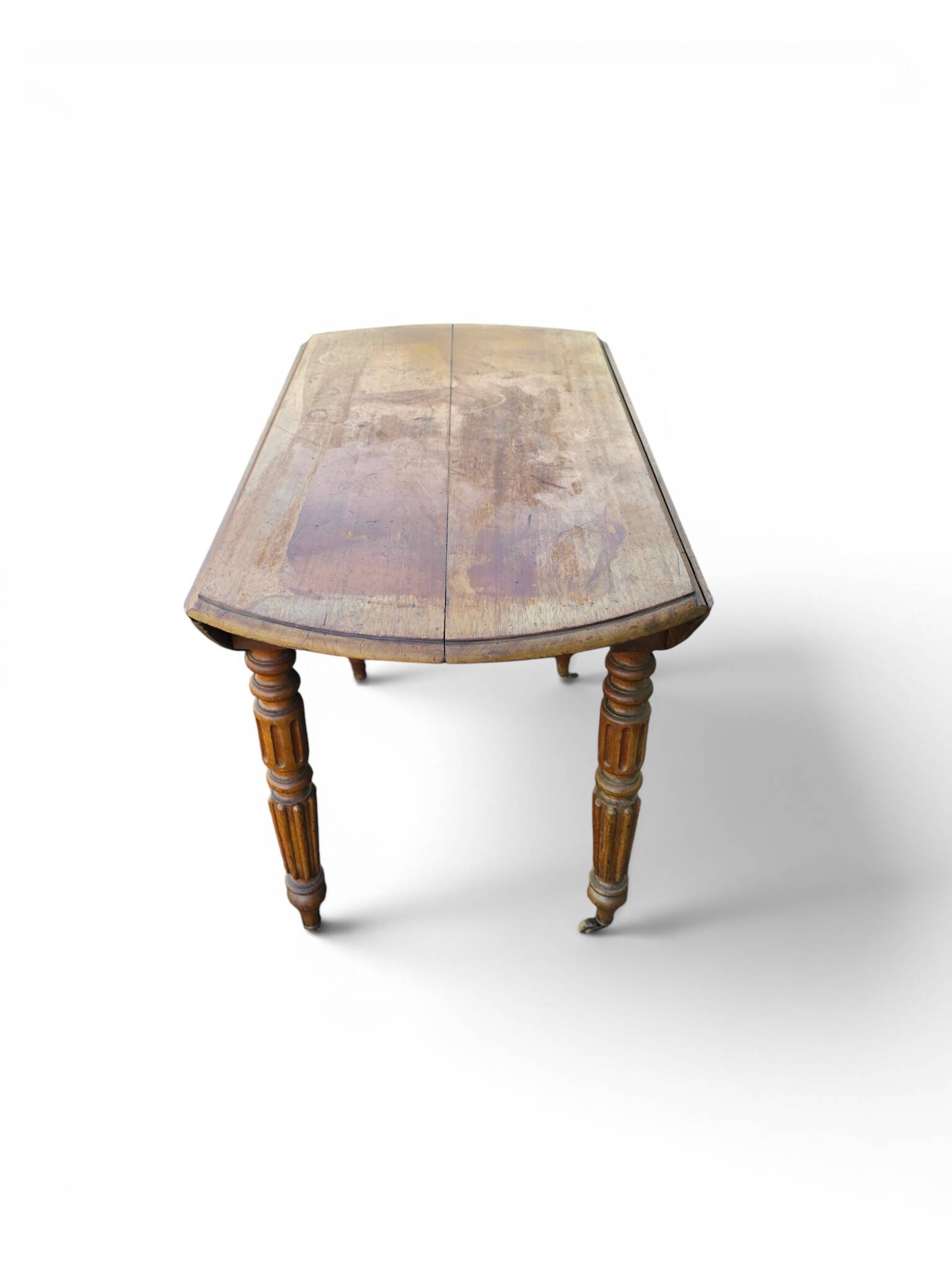 Antique drop-leaf table in wood, with turned legs and castors.