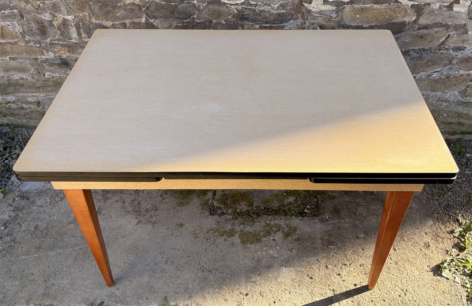 Beige French modernist extendable table, wooden legs, circa 1955.