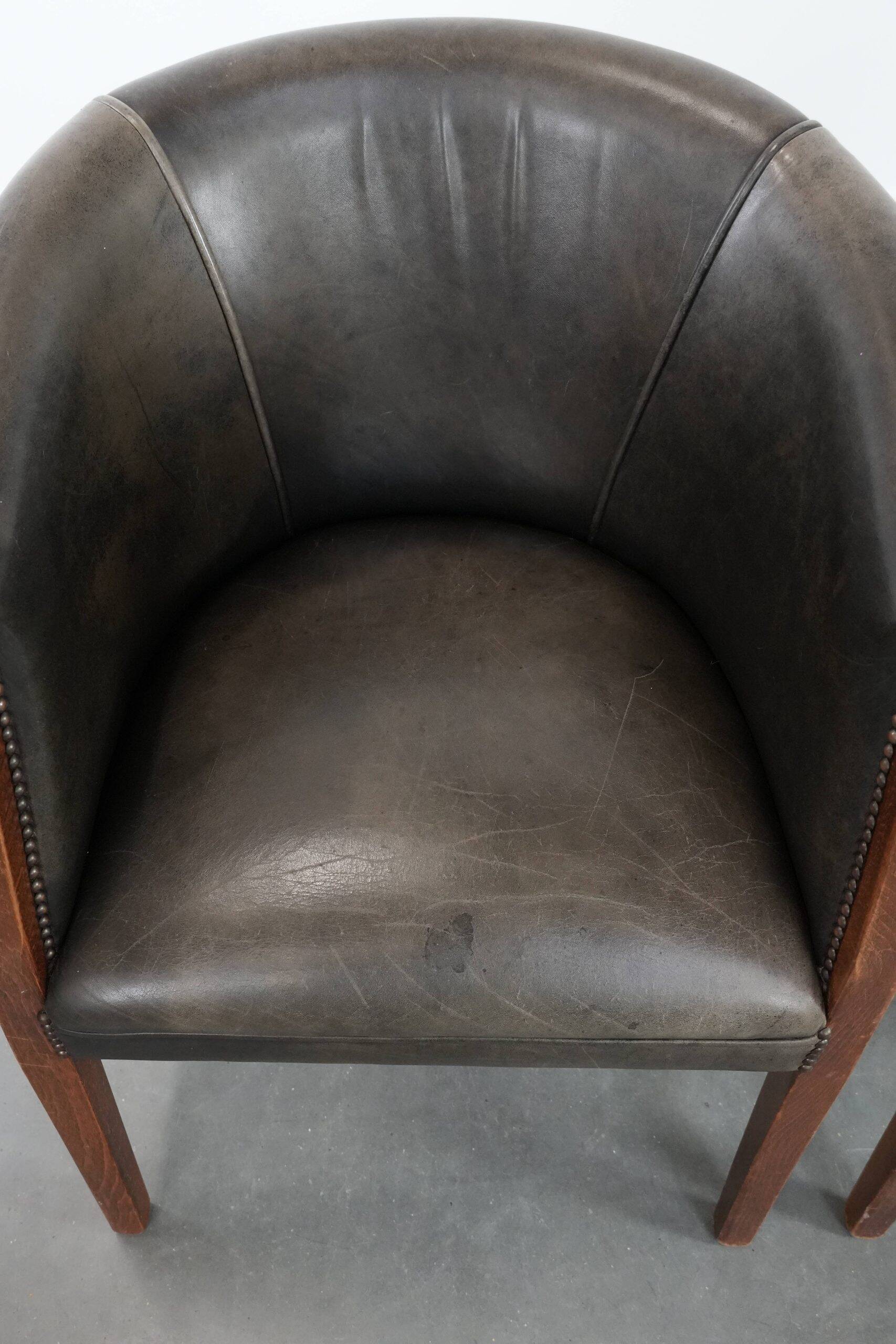 Set of two cowhide and wooden tub chairs with a sturdy colour scheme