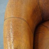 Subtle sheepskin club chair finished with decorative studs