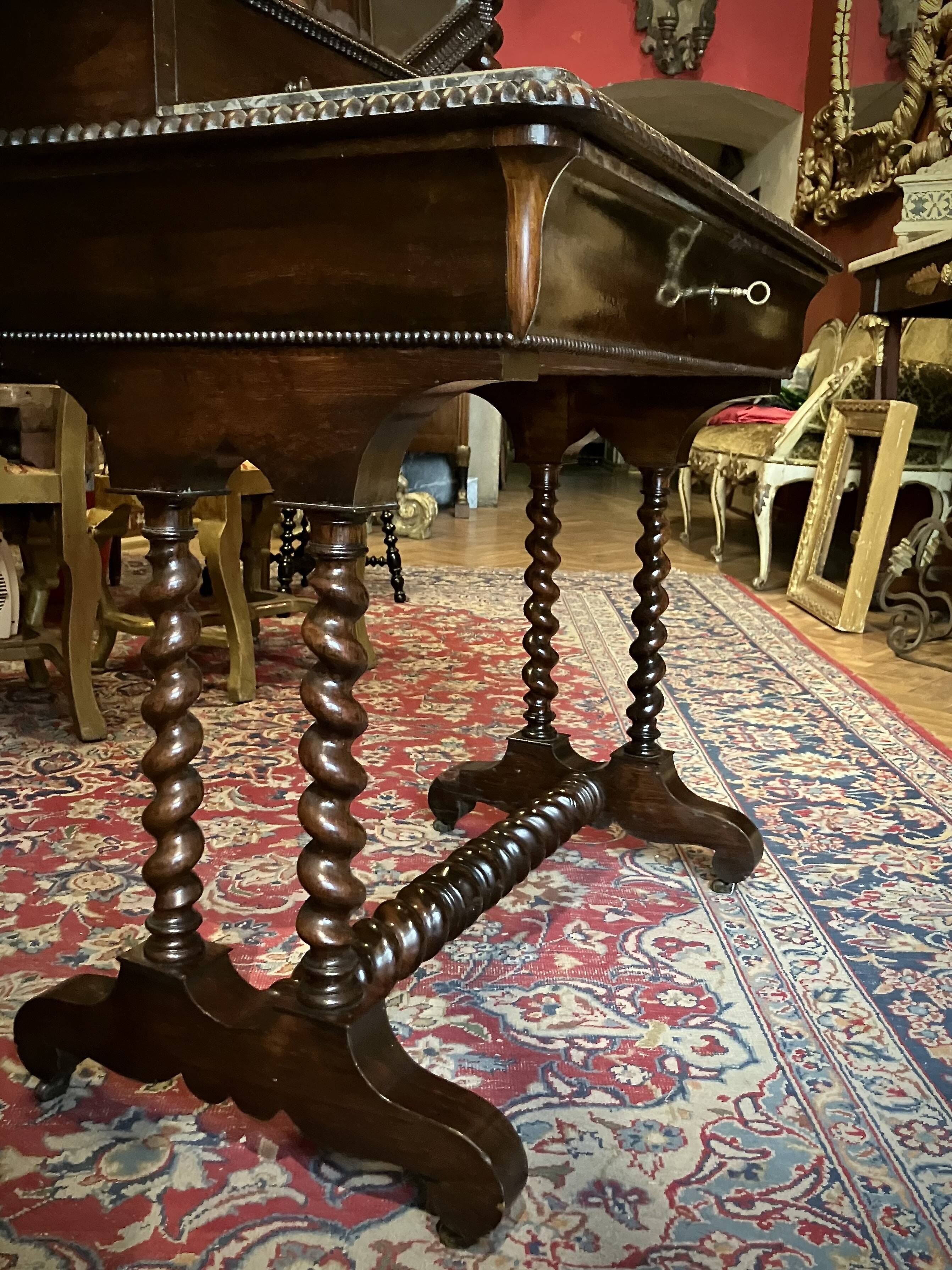 Antique English mahogany dressing table with carved details, black marble, and mirror.