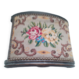 Antique carved stool in an arched shape covered in handmade tapestry