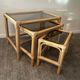 Trio of vintage pull-out tables in rattan and smoked glass 70s