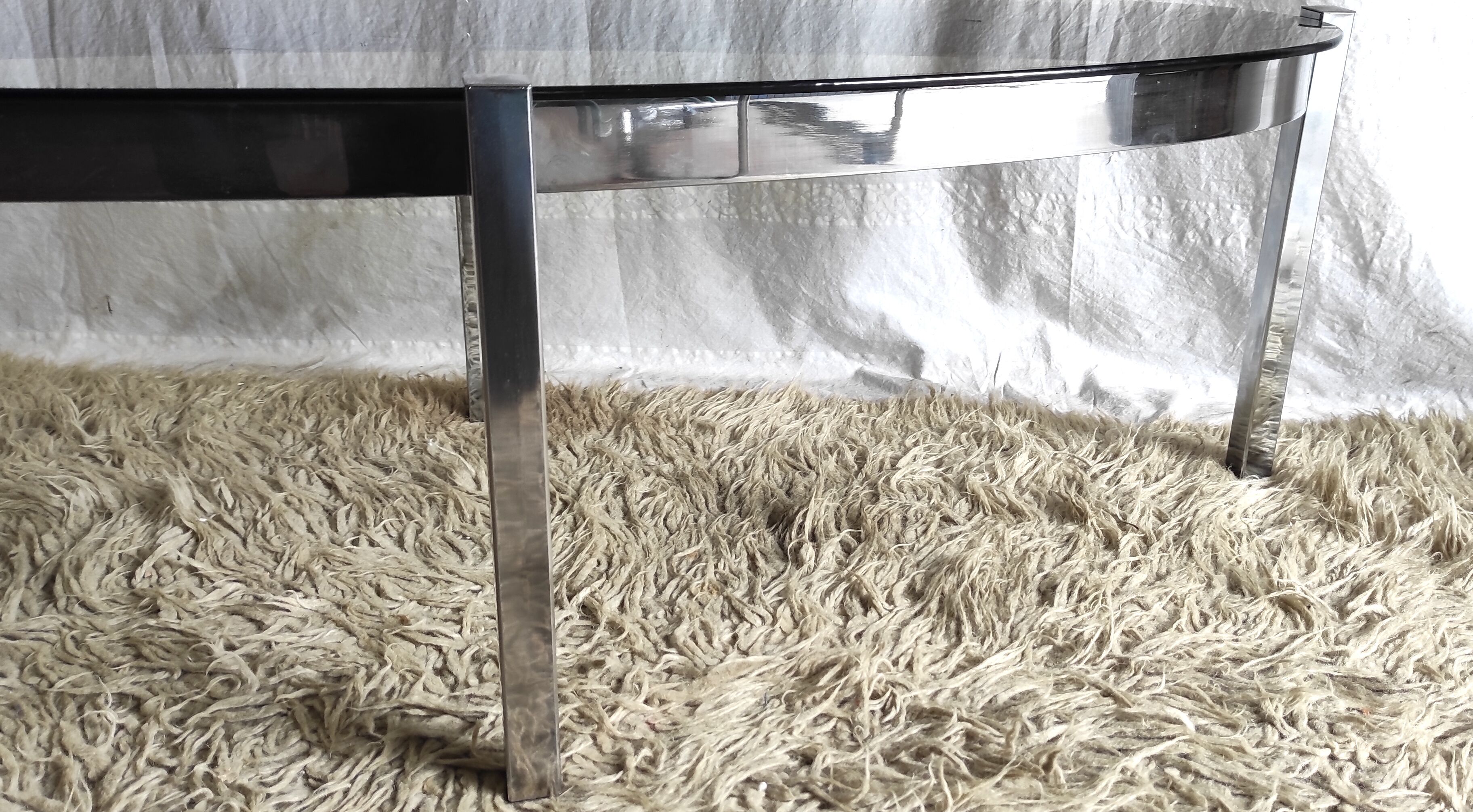 Table basse de forme élyptique en metal chomé et verre fumé, années 70