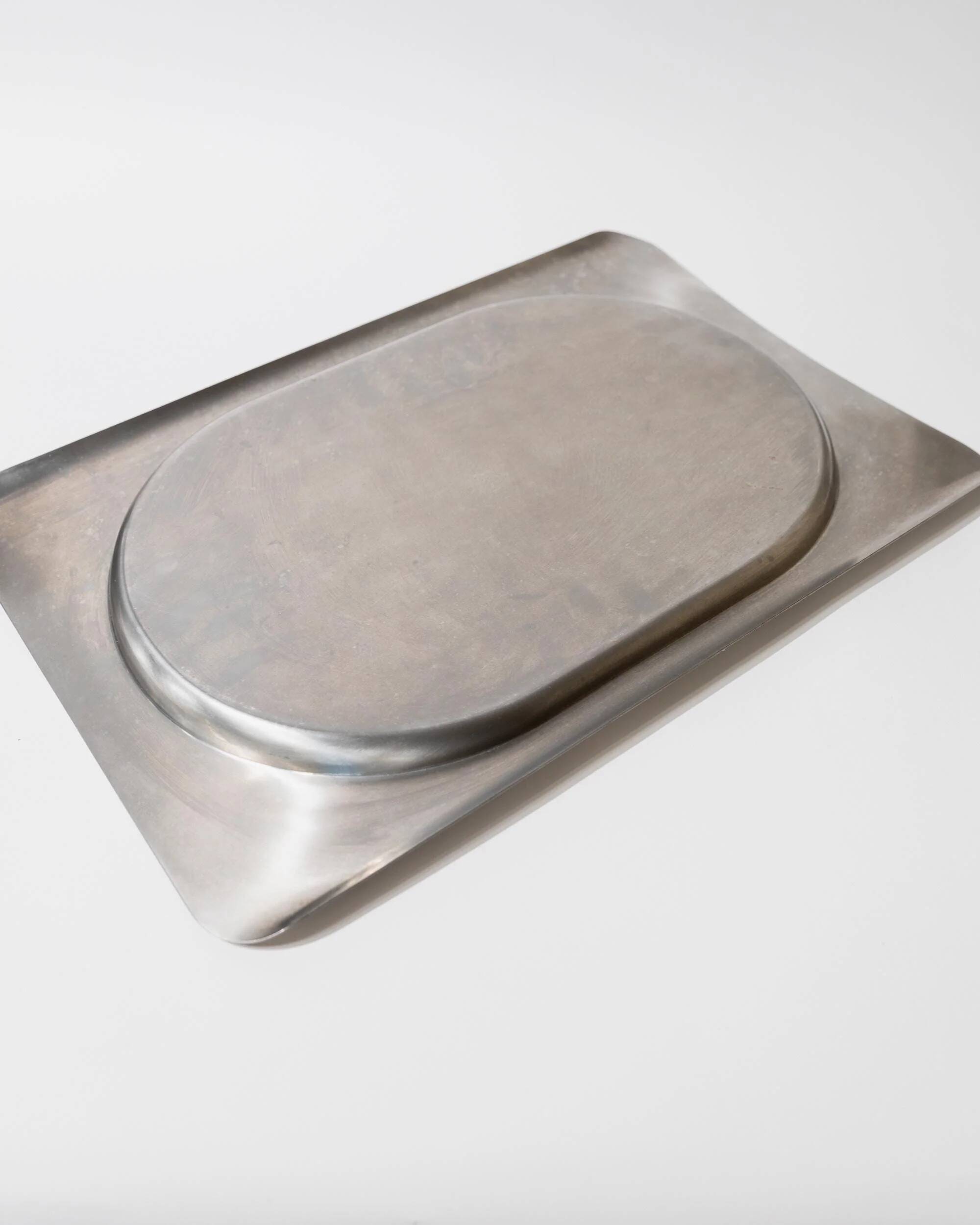 1990s vintage stainless steel platter, rectangular with an oval indentation, minimalist modern design.