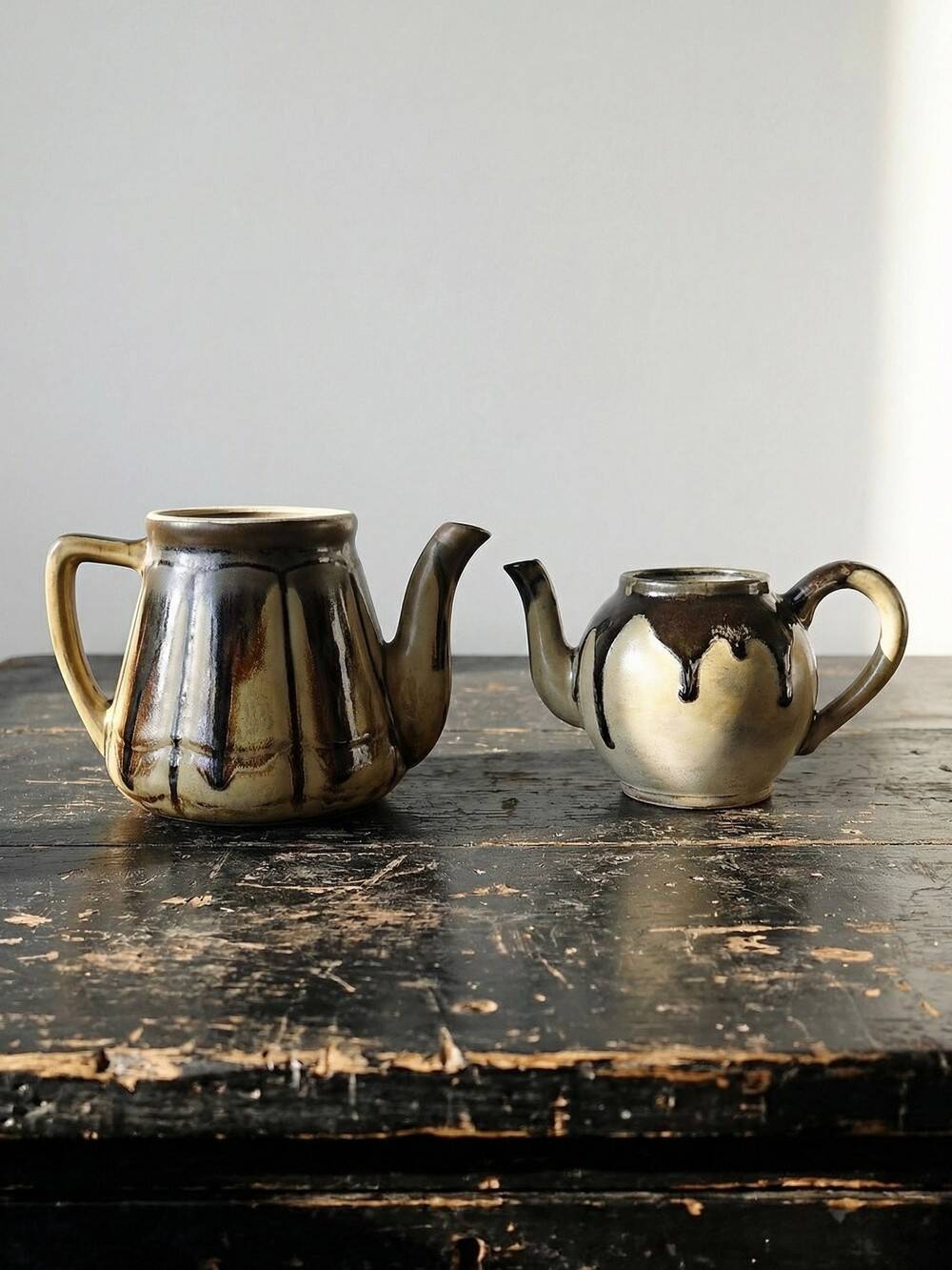 A pair of small vintage teapots in the Art Deco style reminiscent of Denbac.
