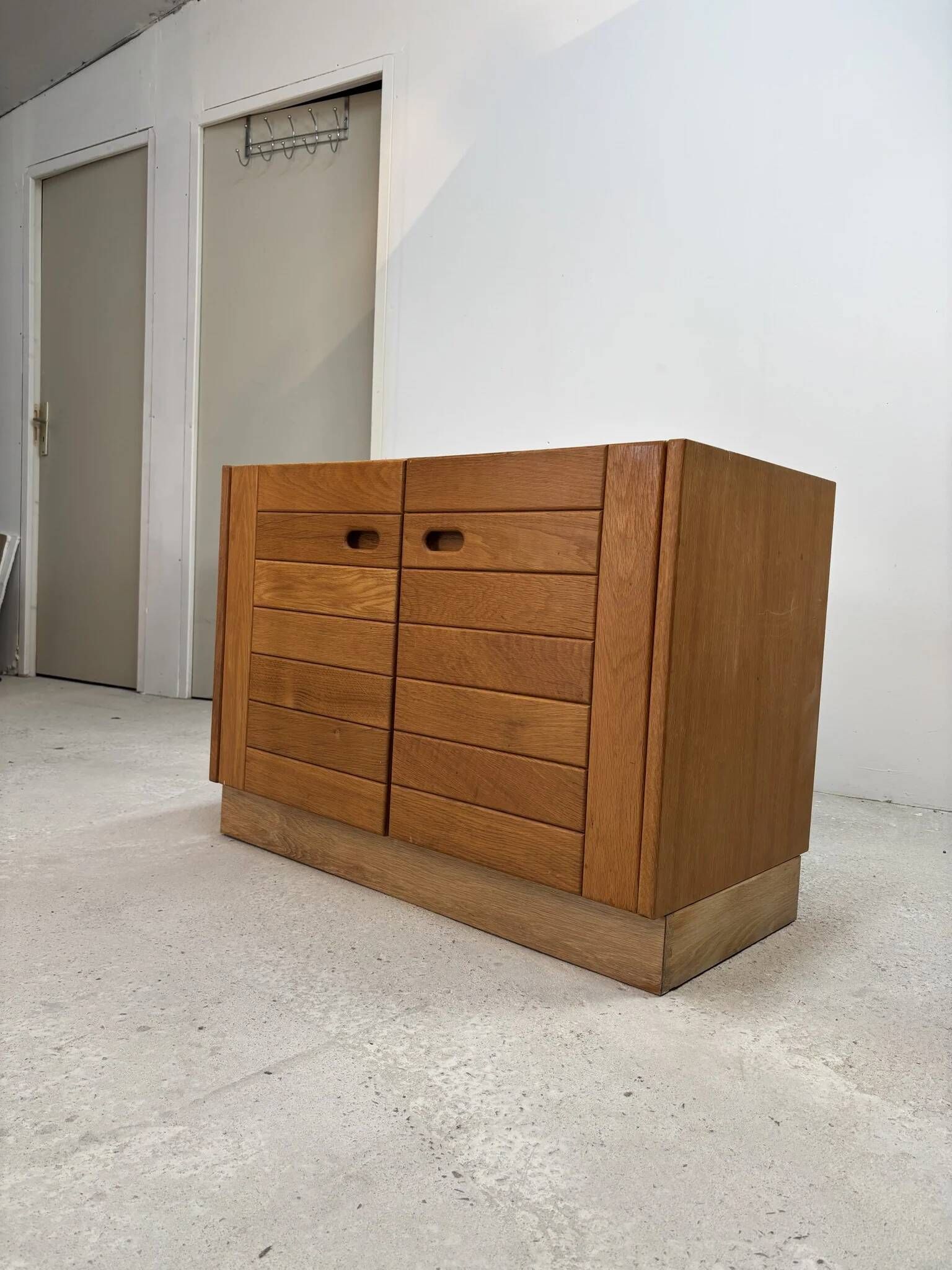 Low buffet with horizontal fronts and recessed handles in the spirit of the Regain house.