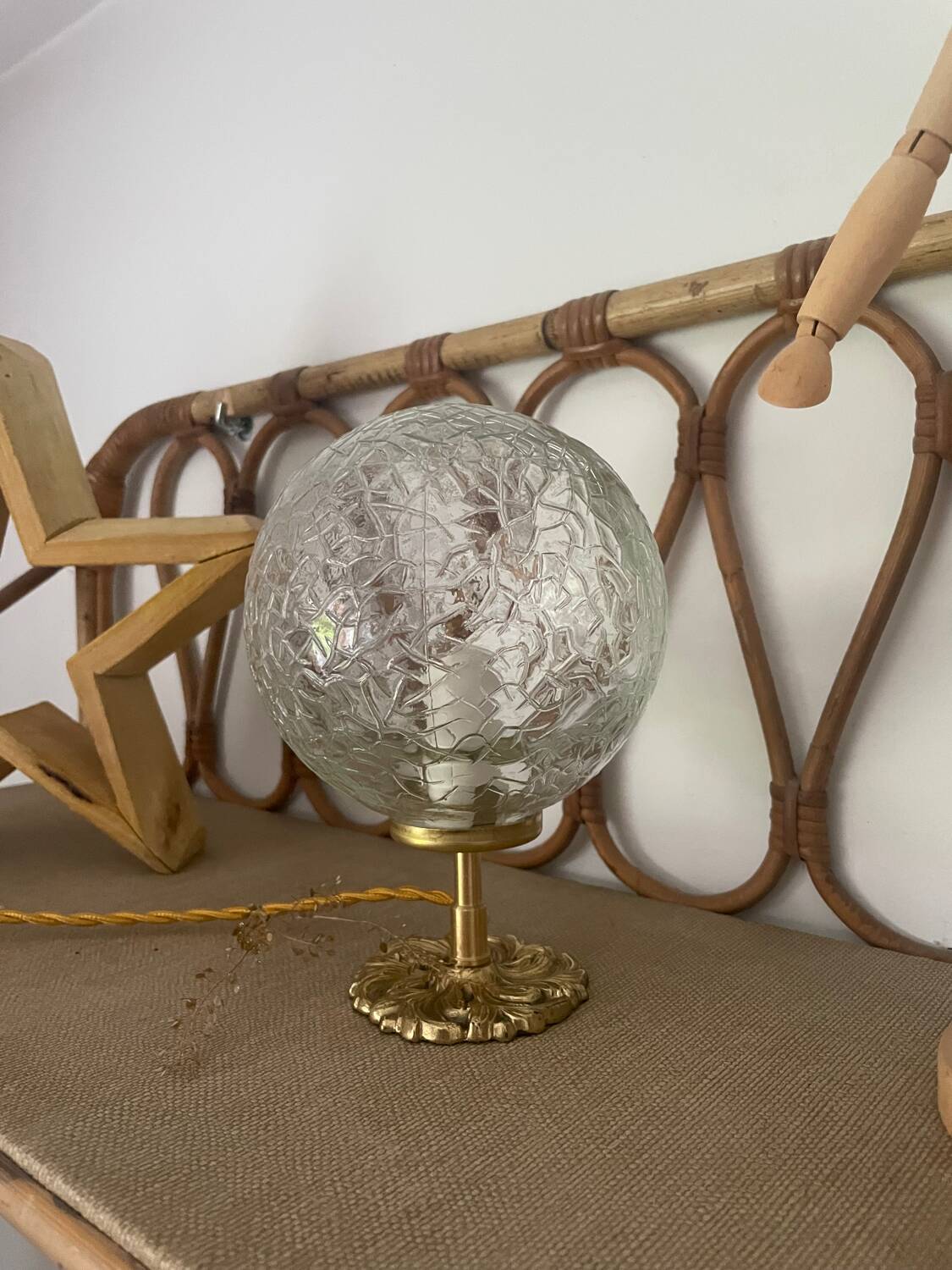 Small handcrafted globe lamp with a cracked finish and a golden brass base.
