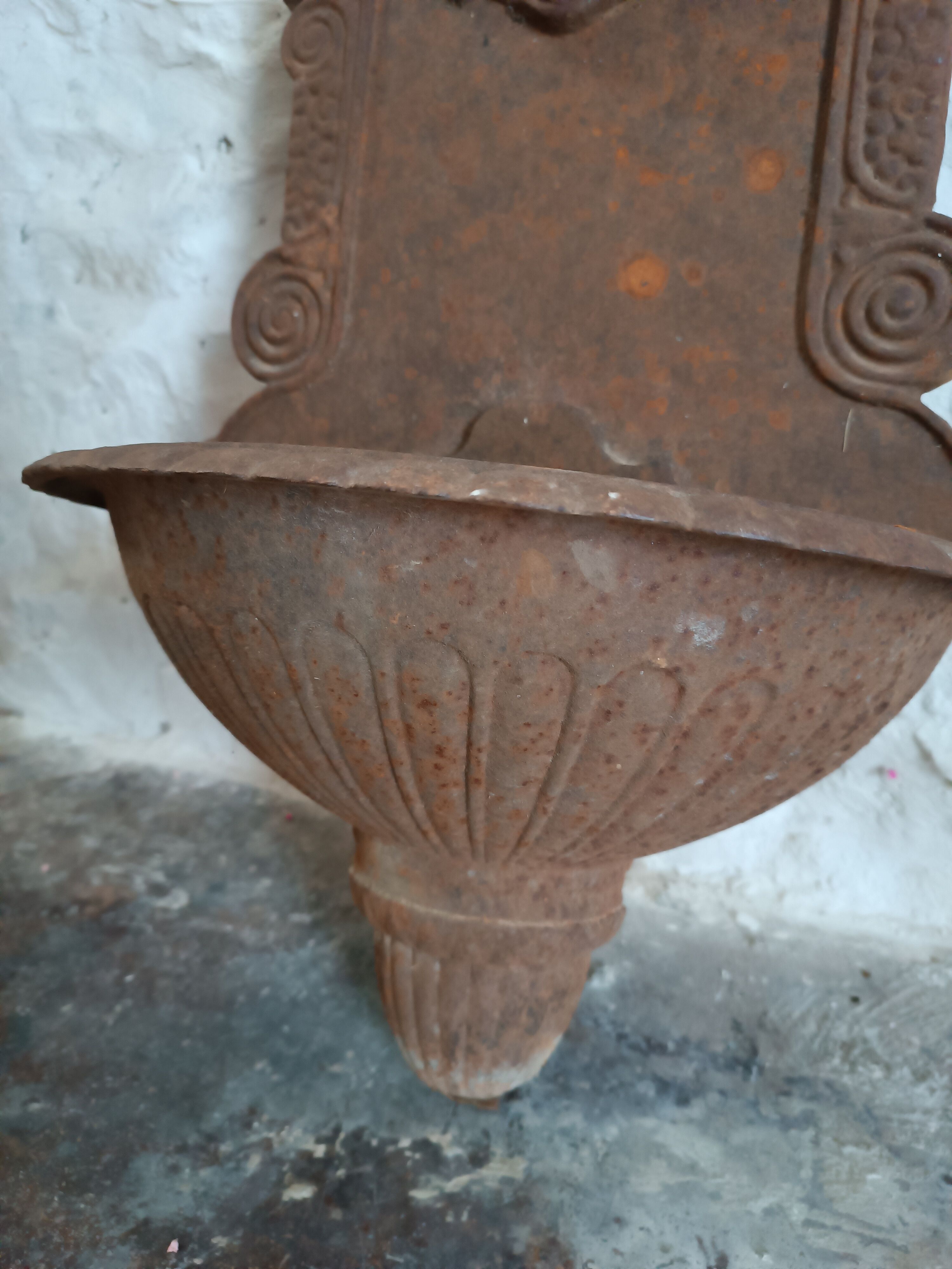 Old cast iron wall fountain with lion's head