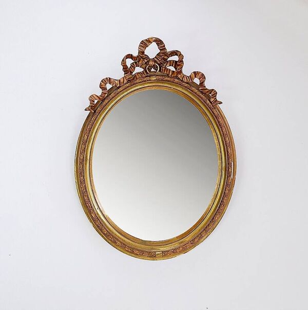 Wear consistent with age and use  Wood and gilded plaster ''Noeud d'Amour'' Oval mirror