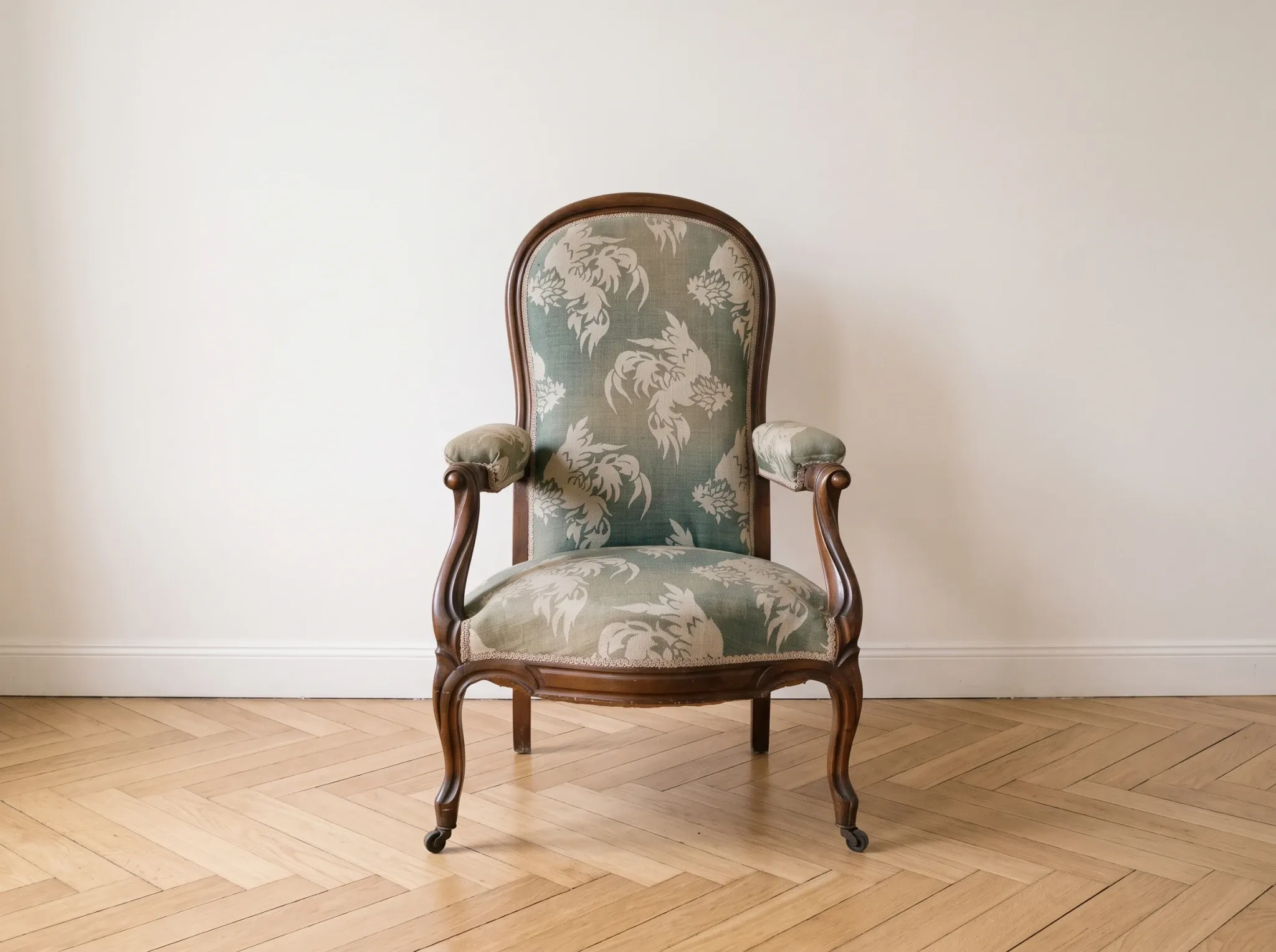Antique Voltaire armchair in wood and green fabric with floral patterns.