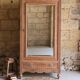 Antique walnut bonnetière with bevelled mirror.