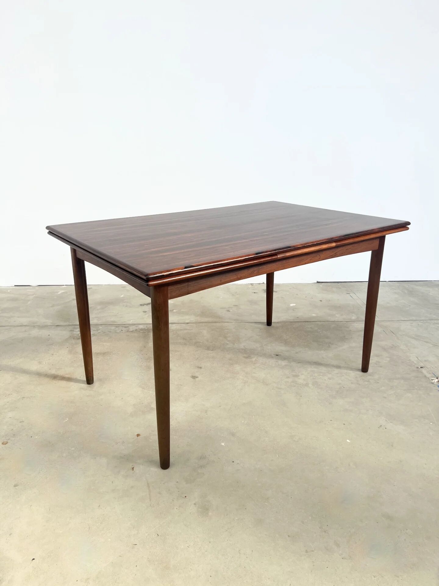 Rosewood dining table with integrated extensions — Denmark, 1960s