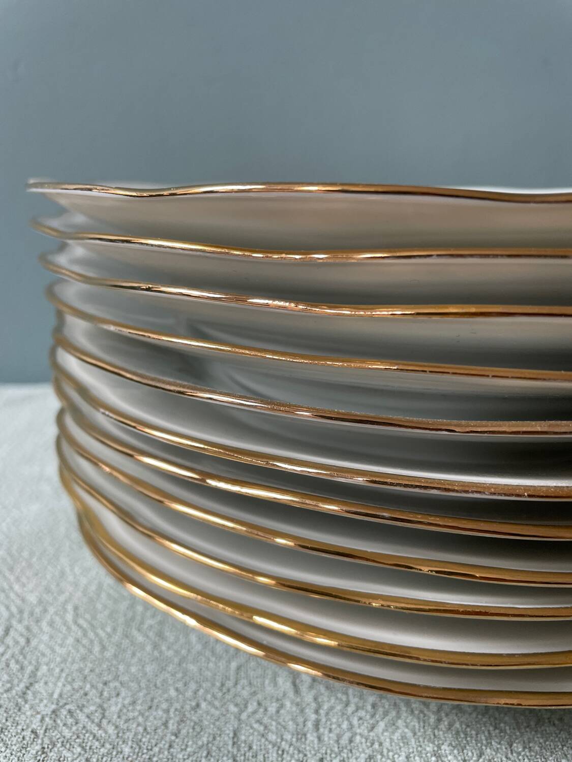 Série de 11 assiettes plates anciennes en porcelaine blanche et liserés dorés