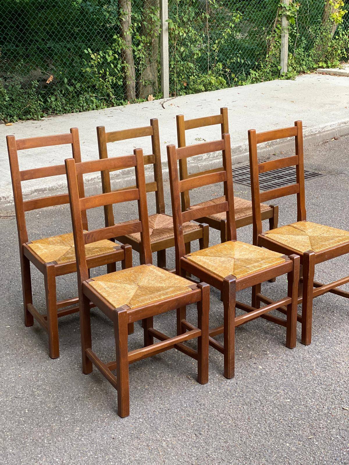 6 light solid wood chairs with high straw backs, farmhouse style.