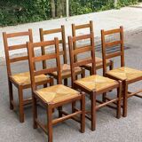 6 light solid wood chairs with high straw backs, farmhouse style.
