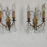 Pair of French antique brass double wall lights with assorted crystals.