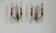 Pair of French antique brass double wall lights with assorted crystals.