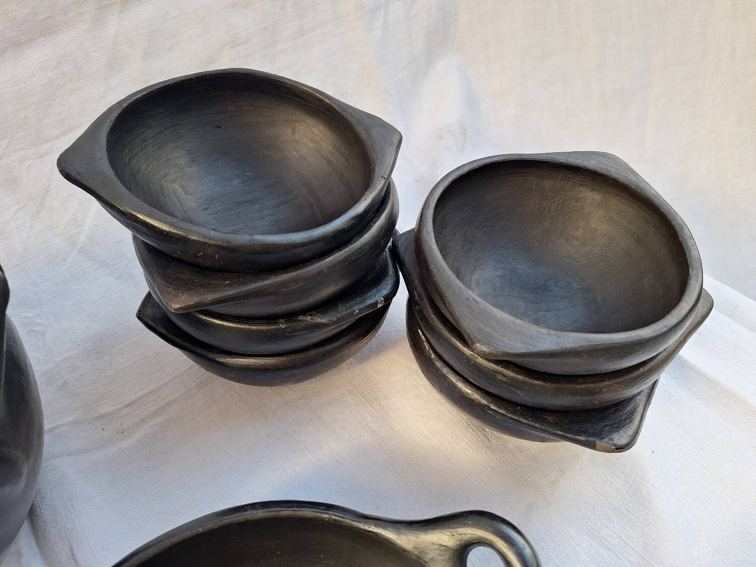 Black terracotta dinnerware set from La Chamba in Colombia. Set of 13 pieces.