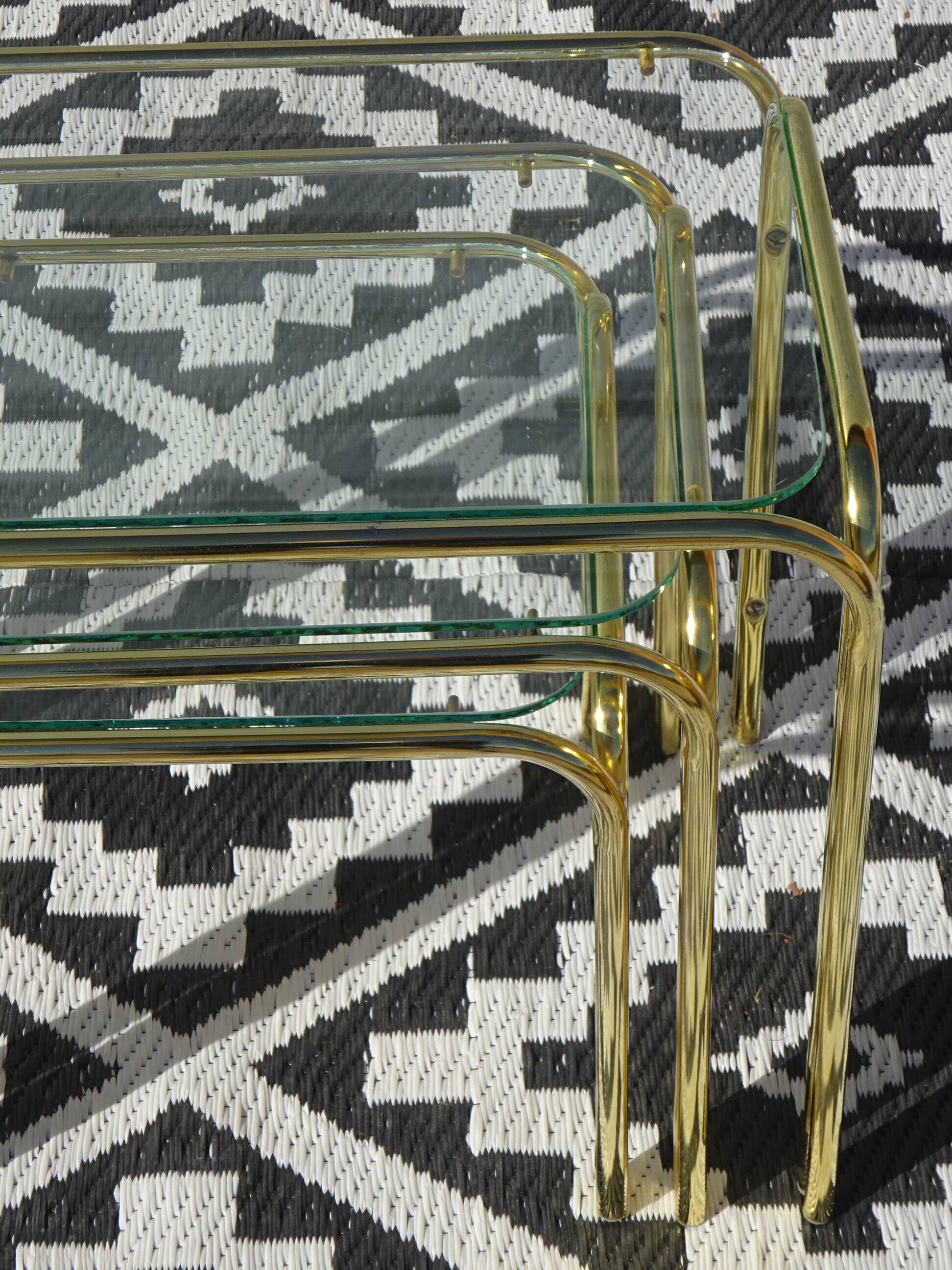 Nested tubular tables in gold metal.