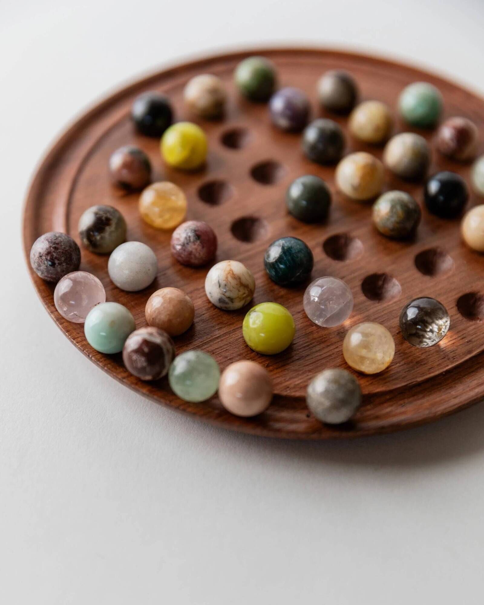 Vintage 1960s solitaire game, wooden board with stone marbles.