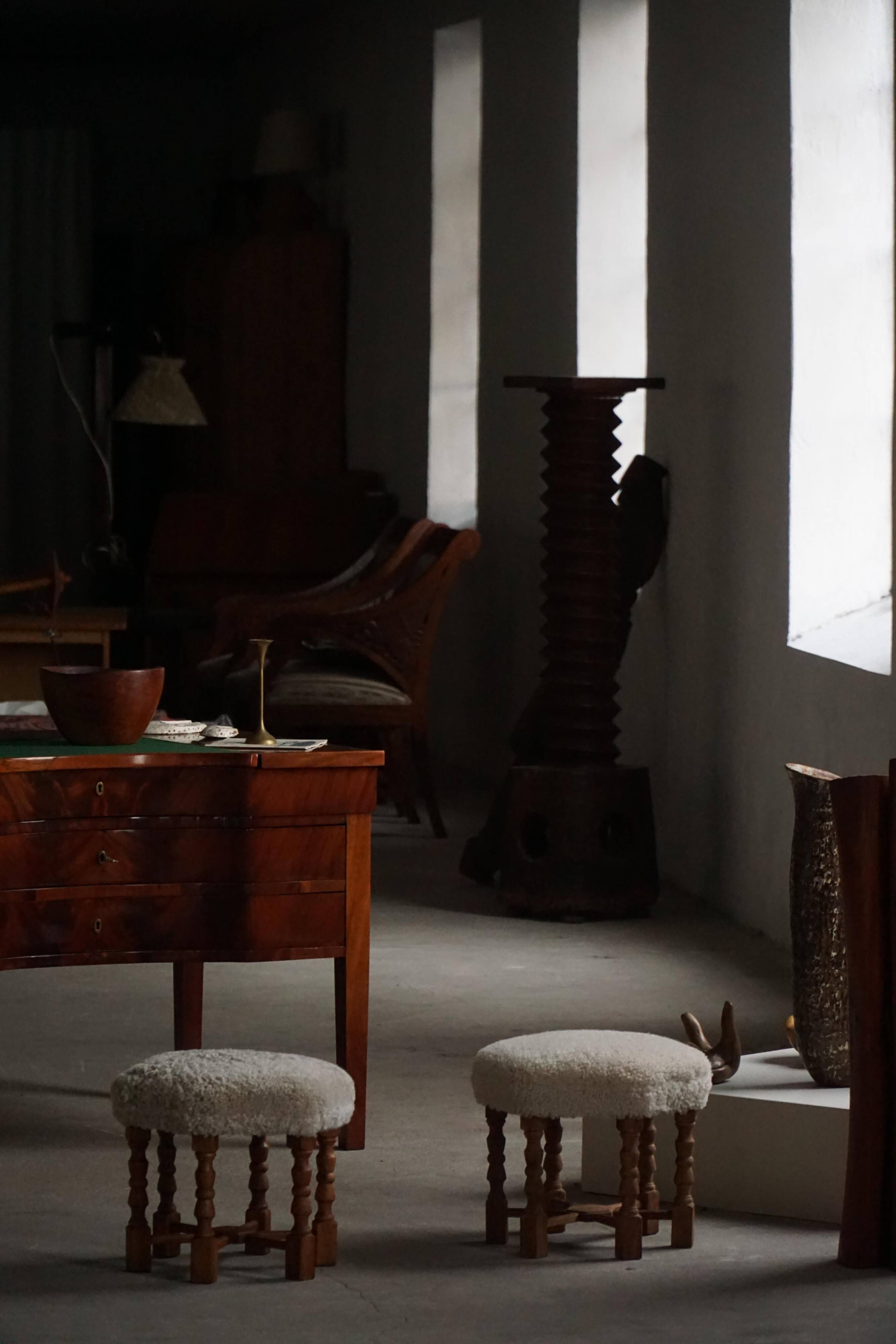 Pair of mid-century Danish oak stools with shearling lambswool upholstery, 1950s.