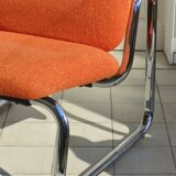 The 1970s orange armchair fabric and chrome metal