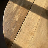 Oval wooden table with drop-leaf edges.