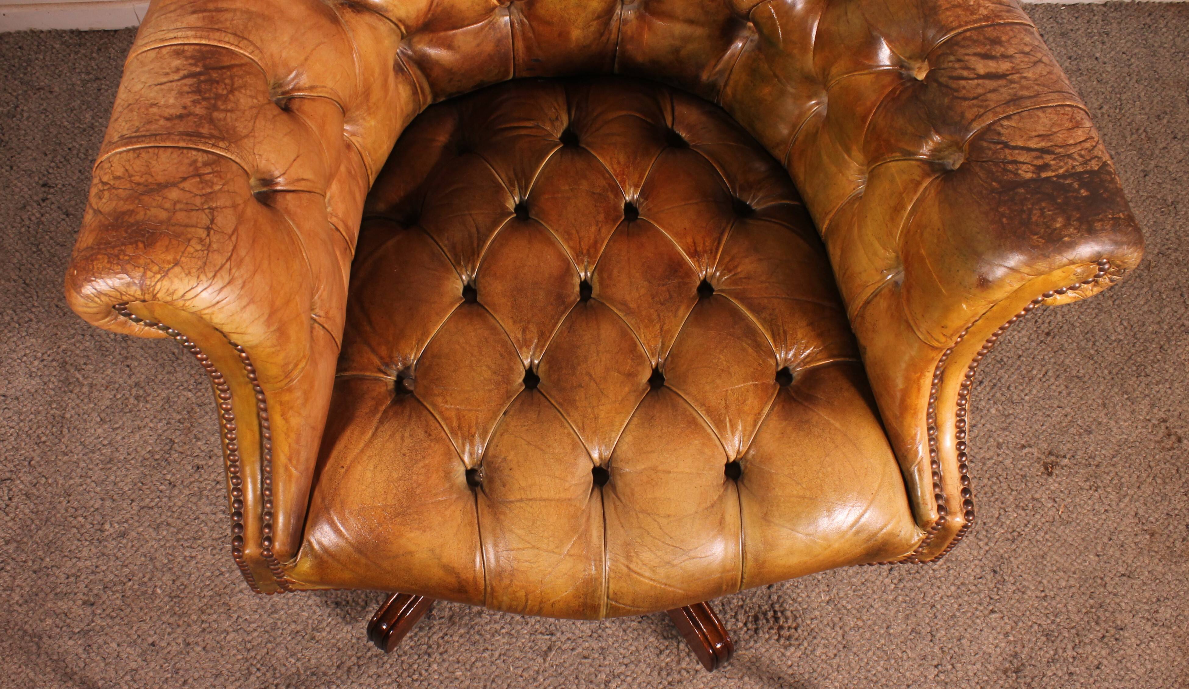 Office chair known as a presidential chair in mahogany and cognac leather.