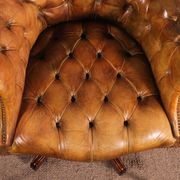 Office chair known as a presidential chair in mahogany and cognac leather.