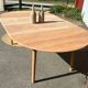 Large round family table with 2 extensions in solid raw wood.