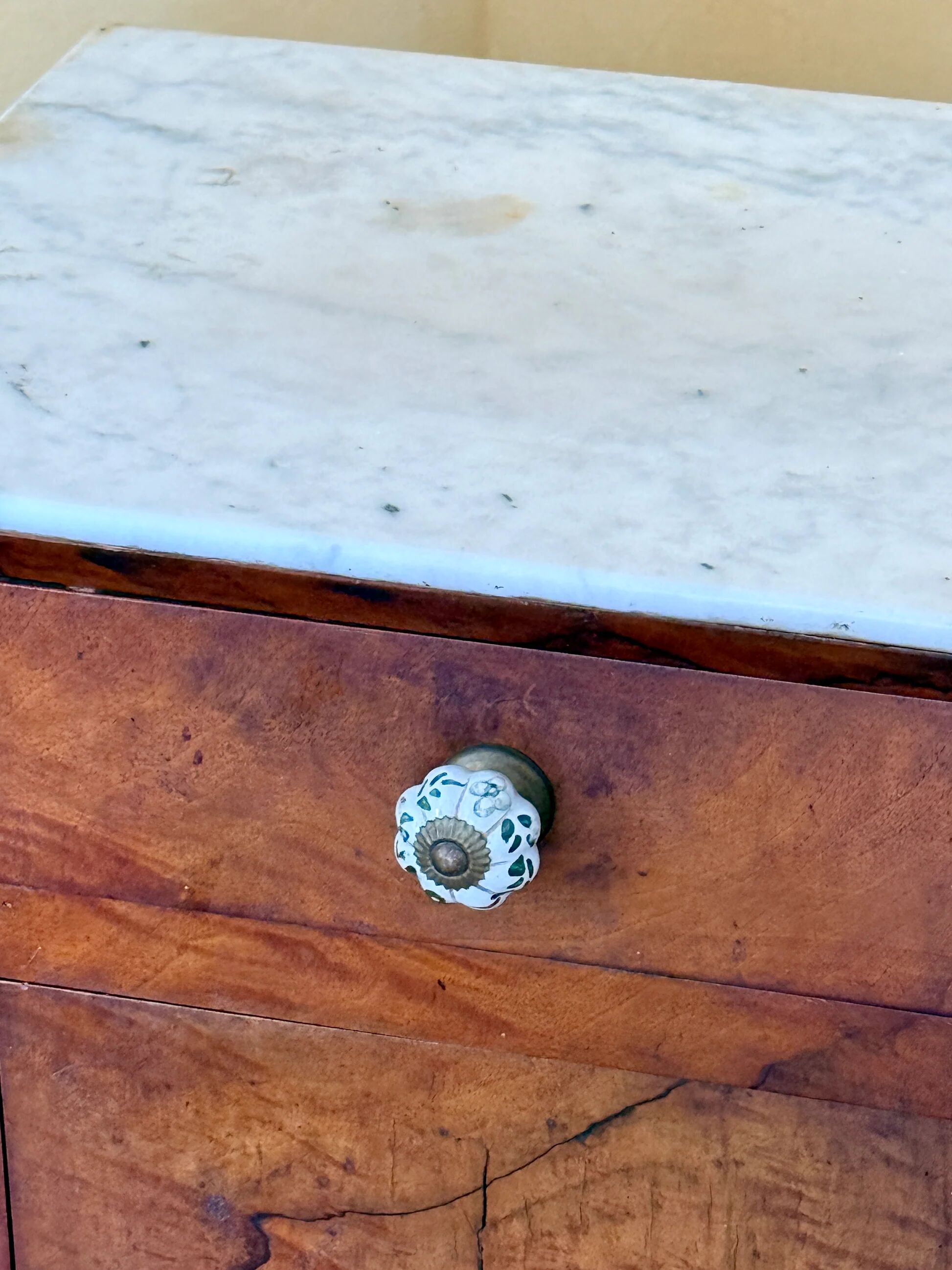 Wood and marble side table with ceramic handles.