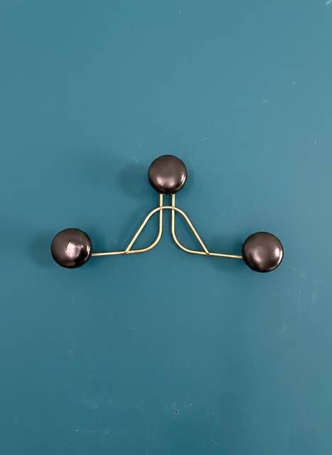 Golden brass coat rack with 3 black vintage hooks from the Mid Century 1950-60.