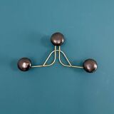 Golden brass coat rack with 3 black vintage hooks from the Mid Century 1950-60.