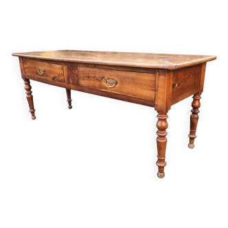 Antique cherry wood farm table with turned base and 2 drawers.