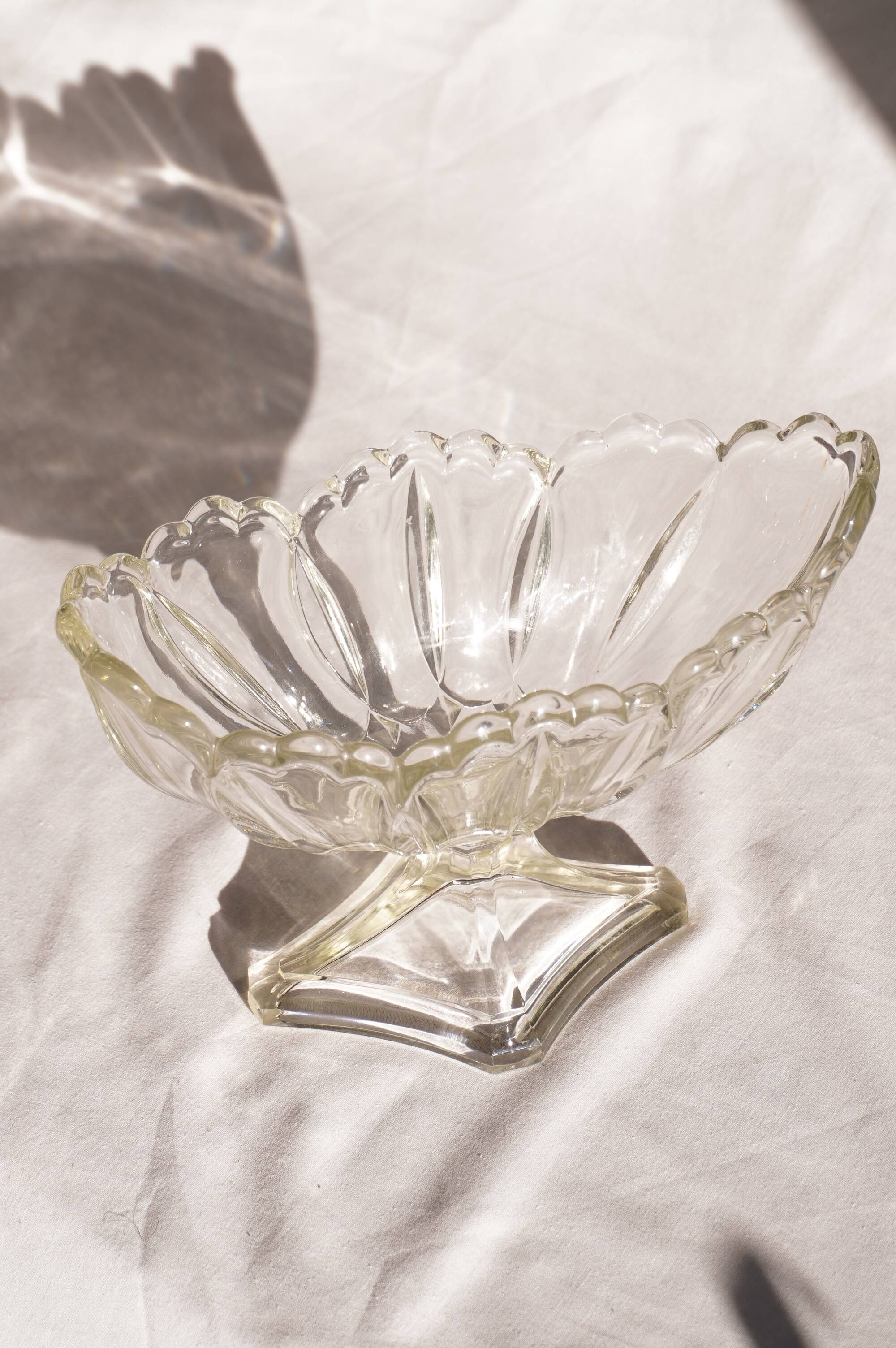Oval glass fruit bowl on a stand.